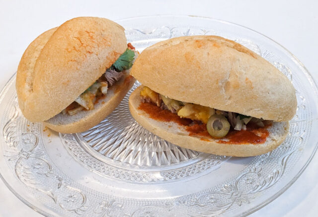 A Tunisian Fricassé street food sandwich - spicy tuna sandwich with eggs and potatoes on a baguette