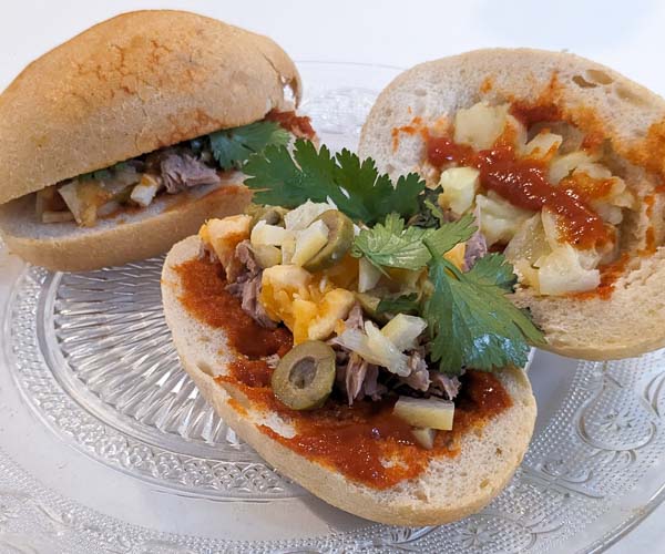 A Tunisian Fricassé street food sandwich - spicy tuna sandwich with eggs and potatoes