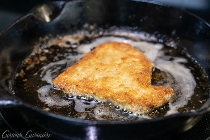 Frying breaded pork for Schweineschnitzel (German Pork Schnitzel)